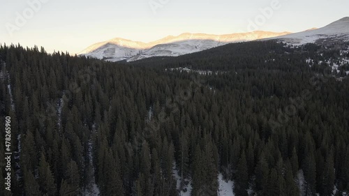 Aerial flight along North Star Mountain towards a mountain pass at sunset, with Hoosier Ridge in the distance. Filmed in the Rocky Mountains of Colorado at Hoosier pass between Breckenridge and Alma. photo