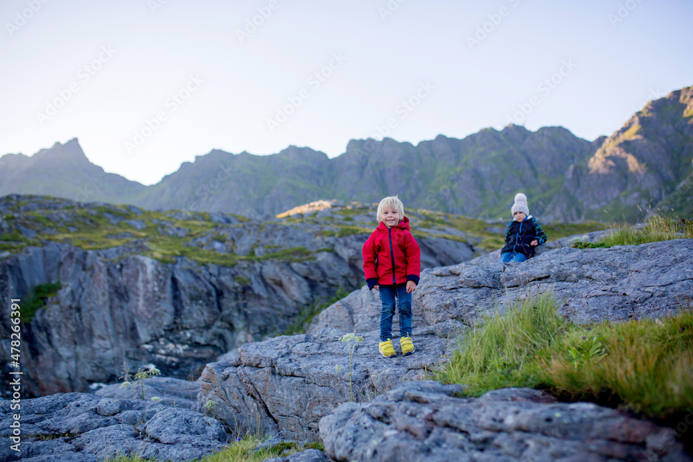 People, enjoying beautiful view of norwegian mountains near A village on a sunny evening, Lofoten, Norway