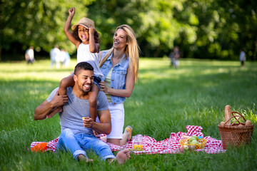 Happy multiethnic family enjoying picnic in nature