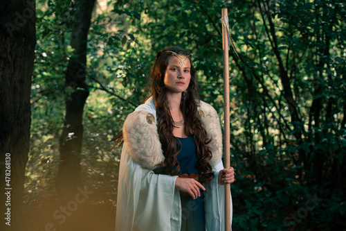 Gorgeous woman in old authentic historical outfit in forest photo