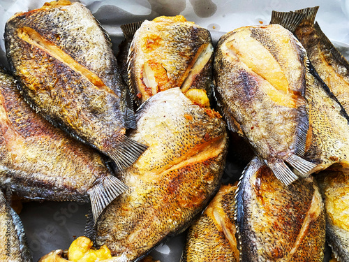 Deep fried Snakeskin gourami fish with spawns on white arches oil paper sheet photo