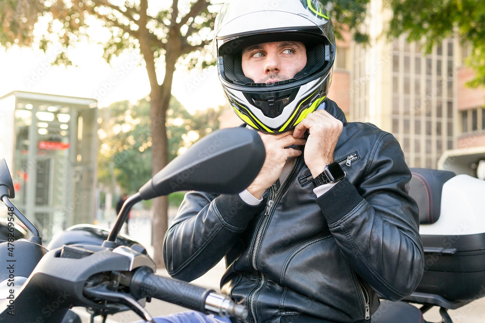 Man putting on helmet on motorcycle Man putting on helmet on motorcycle