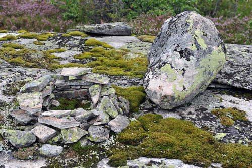 Circle of rocks with moss in mountain area.  Big boulder to the right of stone circle. Horizontal photo.
