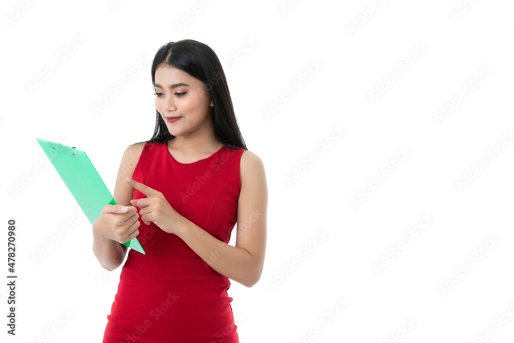Happy beautiful young Asian business woman in casual business red dress is smiling, pointing on green clipboard while holding and looking on work at board, isolated white background. Clipping path. Happy beautiful young Asian business woman in casual business red dress is smiling, pointing on green clipboard while holding and looking on work at board, isolated white background. Clipping path.