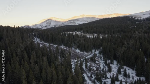 Aerial flight along North Star Mountain towards a mountain pass at sunset, with Hoosier Ridge in the distance. Filmed in the Rocky Mountains of Colorado at Hoosier pass between Breckenridge and Alma. photo