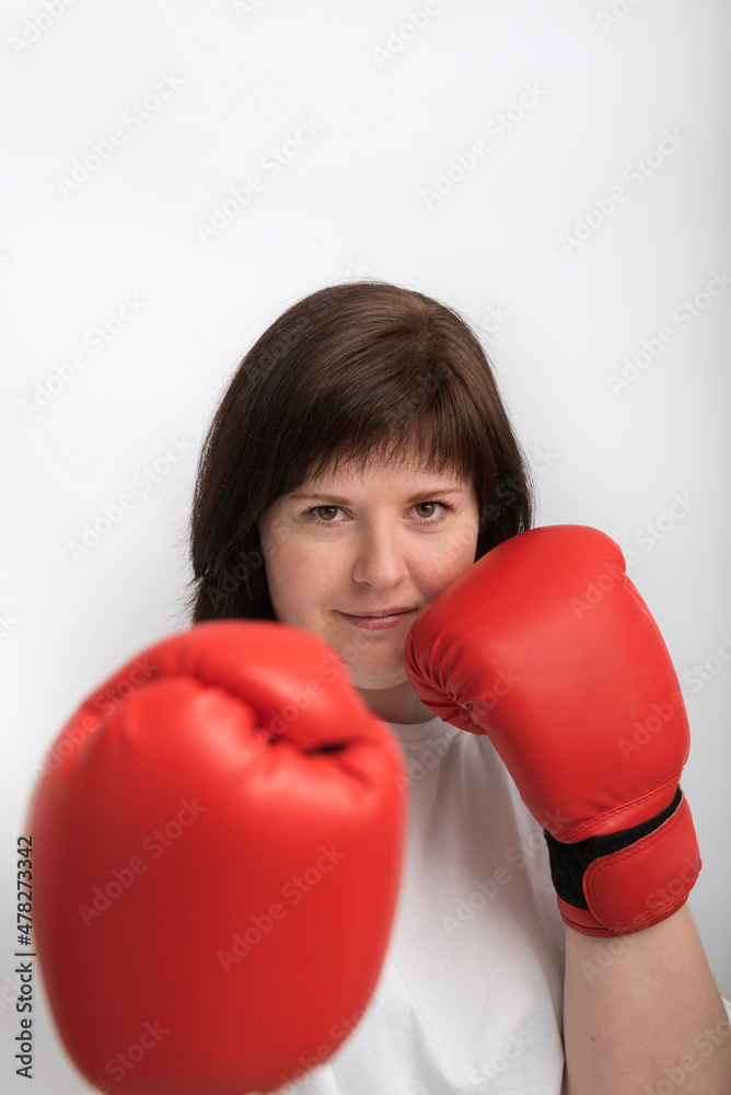 Portrait of confident young woman in boxing gloves on white background. Feminism. Woman fights for justice. Portrait of confident young woman in boxing gloves on white background. Feminism. Woman fights for justice.