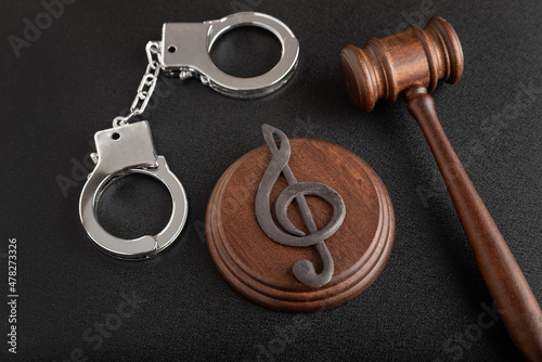 Treble clef sign and handcuffs. Illegal use of someone elses music. Copyright infringement. Music Licensing. photo