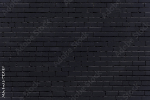 Black brick wall. Background in loft style. Brickwork. Wallpaper made of dark gray brick.