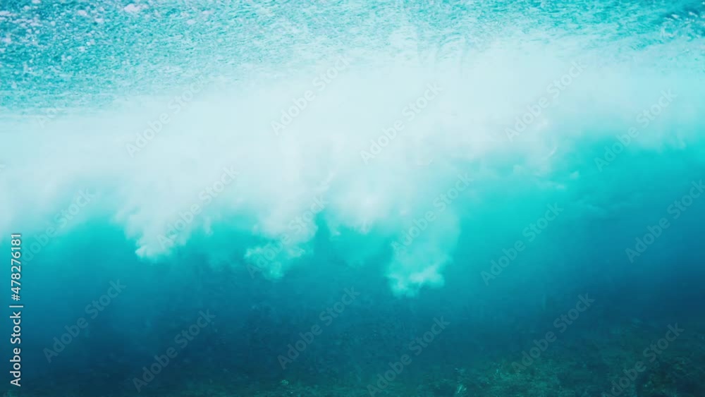 Underwater view of the surfer riding the crystal clear wave Underwater view of the surfer riding the crystal clear wave