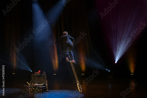 Juggler clown in the circus arena on unicycle photo