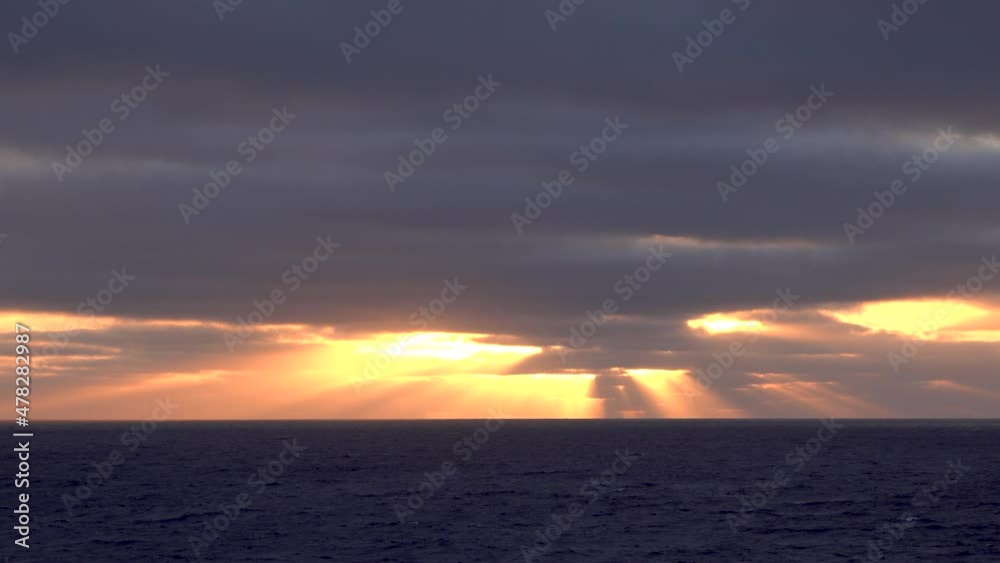 Sunlight appears and disappears from time to time between the clouds. At sunset. The haze is very spectacular. The sunset seen from the boat. North Pacific Ocean, June, 2019. Sunlight appears and disappears from time to time between the clouds. At sunset. The haze is very spectacular. The sunset seen from the boat. North Pacific Ocean, June, 2019.