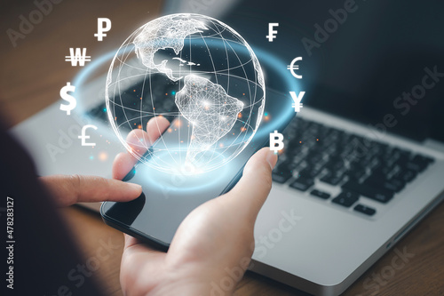 Man using mobile phone and laptop computer to money transfers and currency exchanges between countries of the world. online banking interbank payment concept. photo