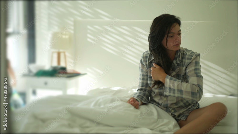 Woman sitting in bed in the morning wearing pajama Woman sitting in bed in the morning wearing pajama