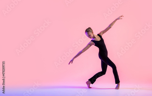 Young teenager dancer dancing on a red studio background. Ballet, dance, art, modernity, choreography concept © Maria Moroz