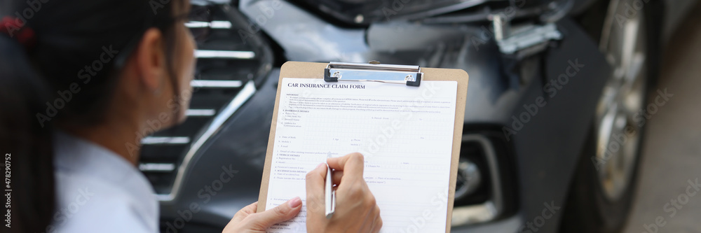 Woman insurance agent fills out insurance form for car damage after traffic accident Woman insurance agent fills out insurance form for car damage after traffic accident