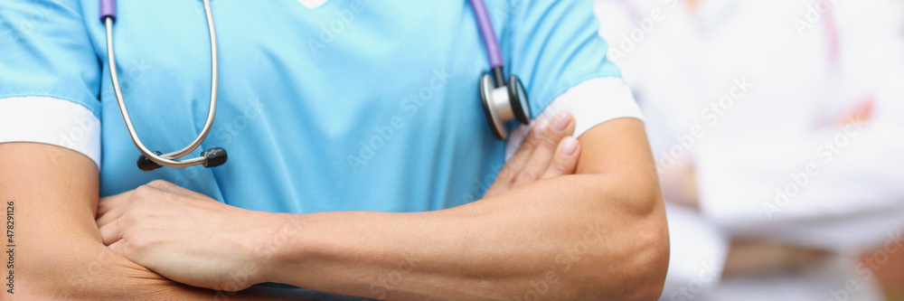 Fototapeta premium Two doctors stand confidently with folded hands closeup