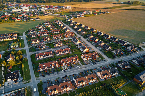 Fototapeta Naklejka Na Ścianę i Meble -  Aerial view of suburban neighborhood, Residential district with buildings and streets at small european town at sunset