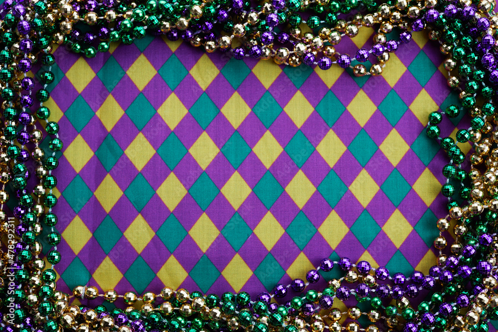 Mardi gras frame of three colours of beads on diamonds background pattern fabric. - obrazy, fototapety, plakaty 