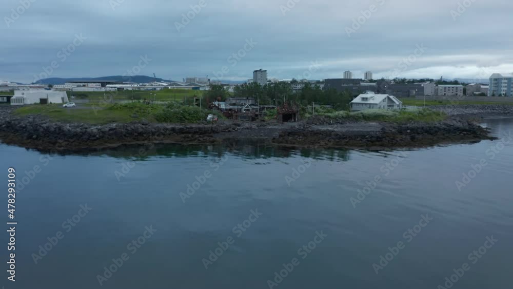 Aerial view of characteristic fisherman house in Reykjavik on the shore of Faxafloi bay. Fishing wooden house in the arctic ocean. Beautiful small wooden house on the shore Aerial view of characteristic fisherman house in Reykjavik on the shore of Faxafloi bay. Fishing wooden house in the arctic ocean. Beautiful small wooden house on the shore