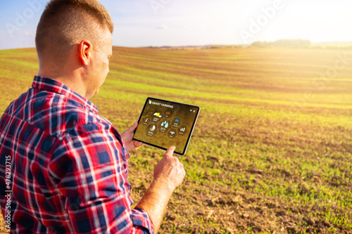 Farmer using tablet computer for smart farming photo