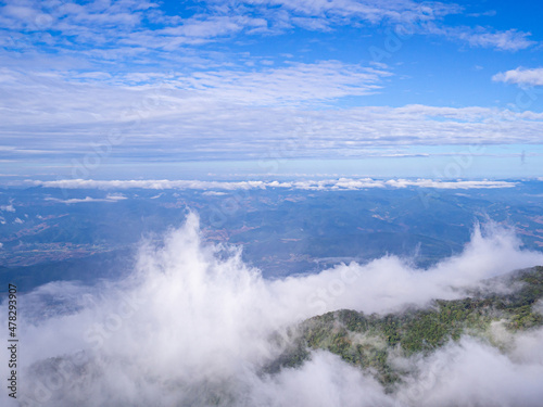 Scenic view of the mountains against fog, clouds, and a blue sky