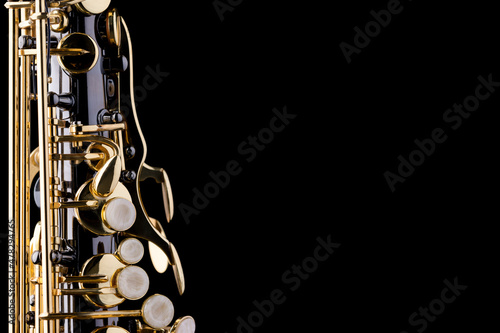 Tela A black saxophone with gold plated keys on a black background