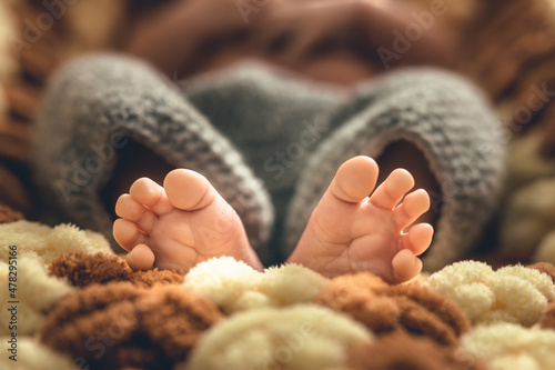 Cute shot of baby feet. Fluffy blanket underneath and wool clothes. Family moments. Baby's first photoshoot. High quality photo