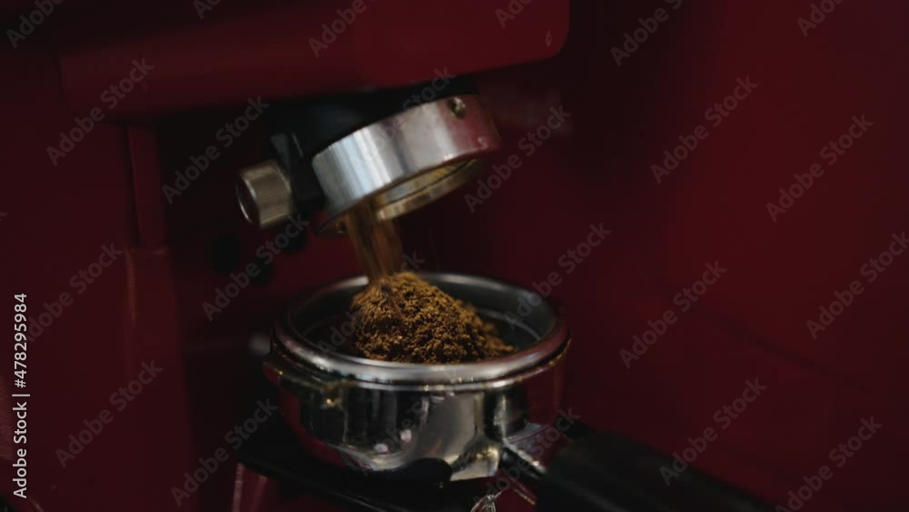Coffee is poured into a cup from a coffee grinder