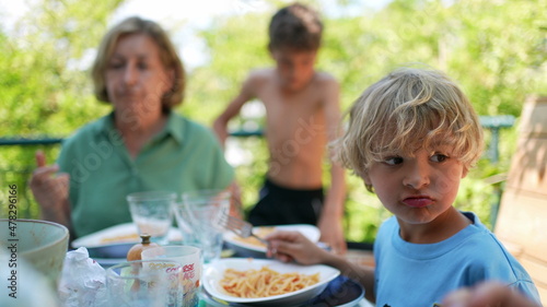 Family eating lunch outside gathered together during meal