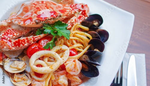 freash seafood pasta with crab, mussels, squid rings, shrimps, clams and toamto sauce photo