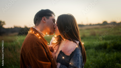 Giovane coppia ragazzo e ragazza con luci led festeggia il san Valentino in un parco naturale photo
