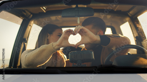 Coppia fa simbolo del cuore per San Valentino in macchina photo