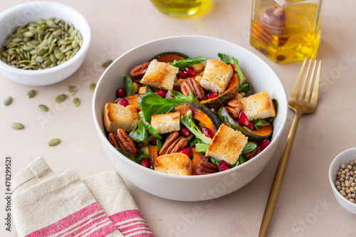 Salad with pumpkin, pomegranate, pecans and croutons. Healthy eating. Vegetarian food.