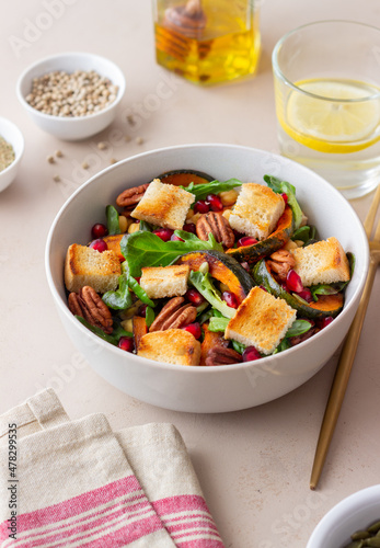 Salad with pumpkin, pomegranate, pecans and croutons. Healthy eating. Vegetarian food.