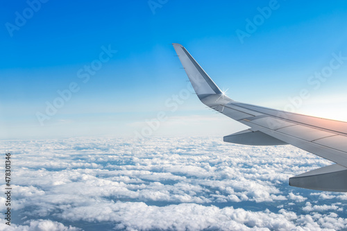 Fototapeta Naklejka Na Ścianę i Meble -  Airplane wing above the clouds. View from airplane window. Air travel and transportation concept. 