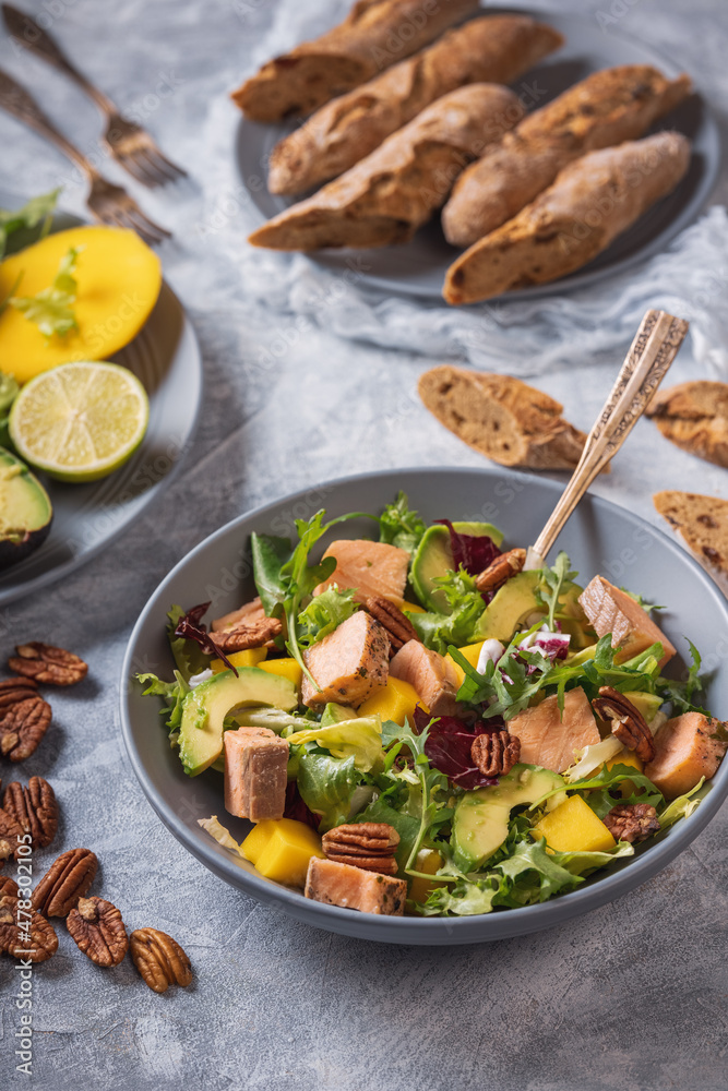 Baked salmon, mango and avocado salad with pecan nuts.