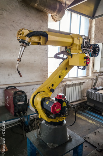 A welding robot in a production room of a mechanical plant. The picture was taken in Russia