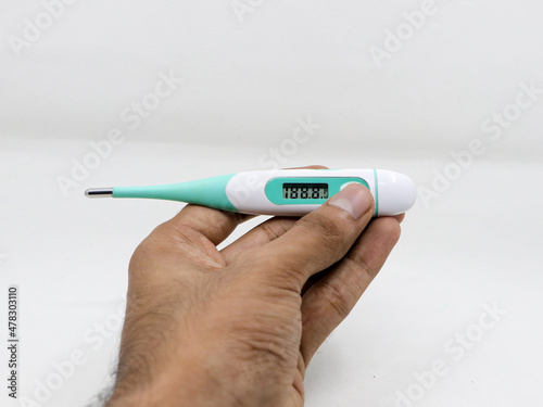 фотографія a digital thermometer with temperature reading in fahrenheit in the hands of a p