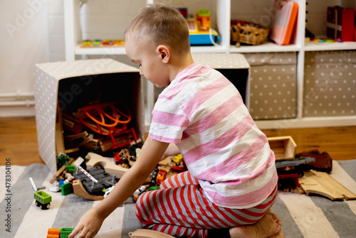 Children pull out wooden rails from a toy box. Educational toys for young children.
