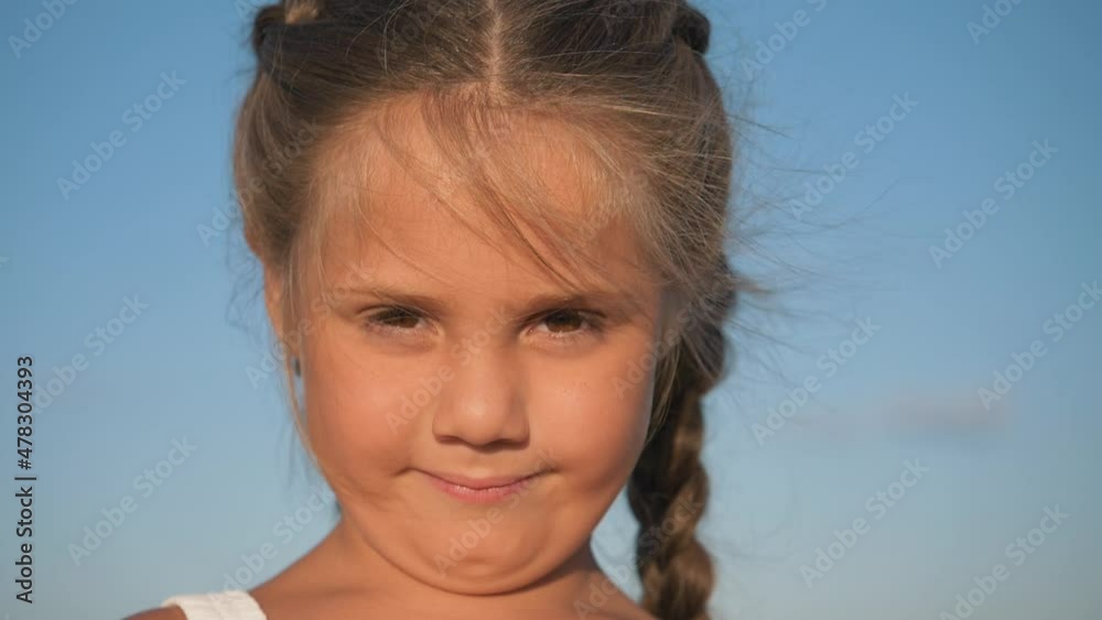 Happy little European girl having fun in the park. Little European girl smiling looks at the camera. Face of healthy happy funny smiling child. Close-up face of a European child. Happy little European girl having fun in the park. Little European girl smiling looks at the camera. Face of healthy happy funny smiling child. Close-up face of a European child.