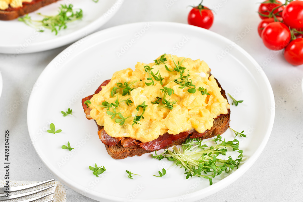 Scrambled eggs with microgreen on bread