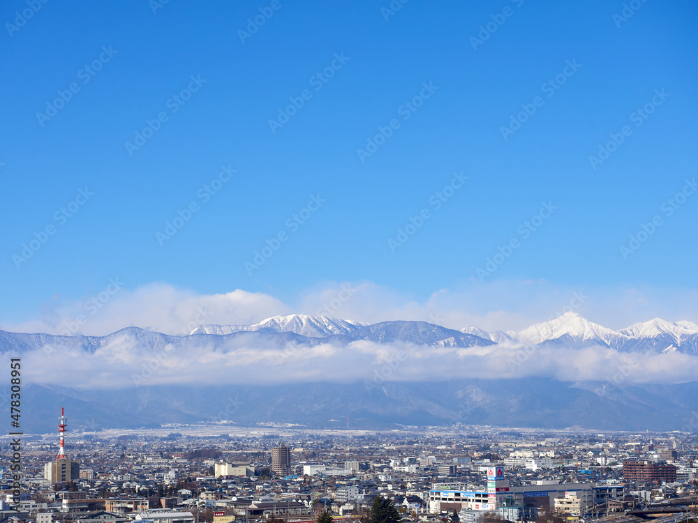 1月（冬）、高台から望む松本の街並みと、雲がかかった北アルプス 長野県松本市