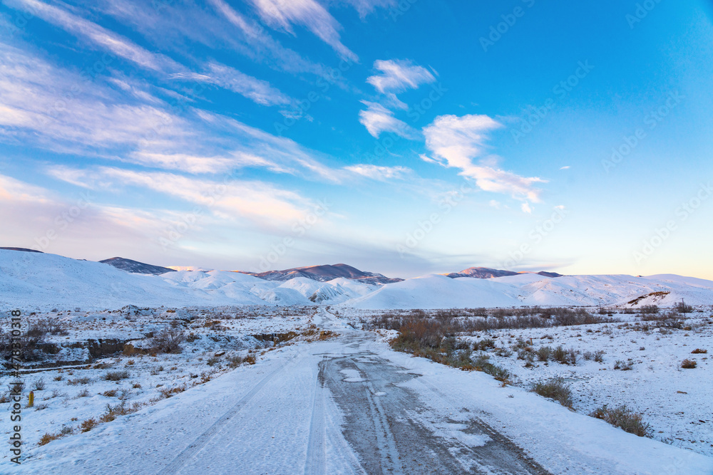 Dirt road to mountains in winter season
