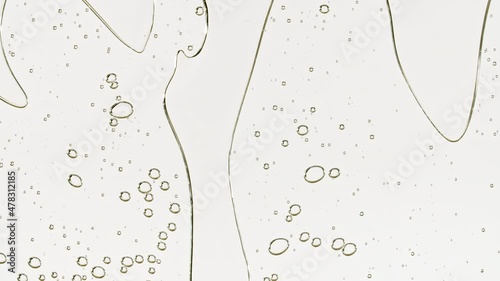 Transparent cosmetic gel fluid with bubbles oil on water silver colored background. Macro Shot. High quality 4k footage