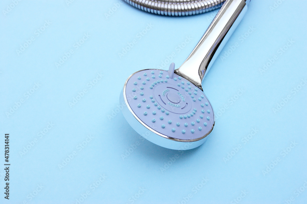 Shower head chrome coated multi-mode for the bathroom with hose on blue background. Shower head chrome coated multi-mode for the bathroom with hose on blue background.