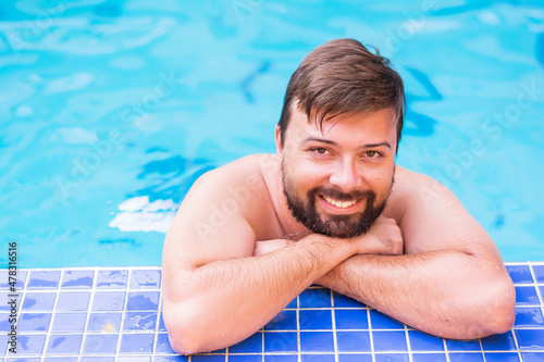 Young attractive smile male with beard in the pool leisure and travel in warm countries in swimming pool. Concept: vacation and weekend in warm countries pool and spa  © Елена Бабанова