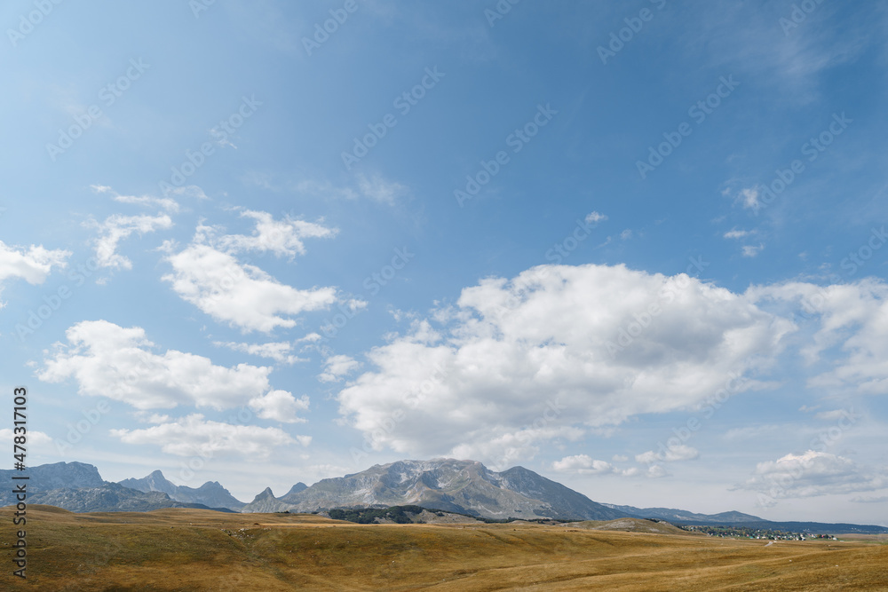 High mountain range over a valley against a blue sky in Durmitor National Park