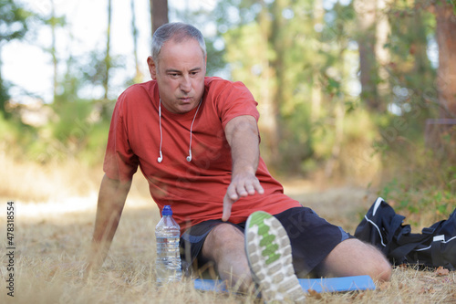 Fotografija male runner stretching outdoors in the forest