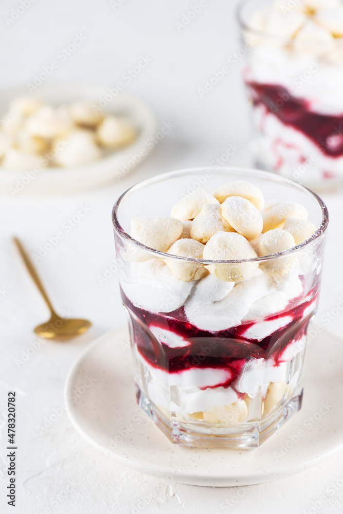 Homemade dessert with aquafaba meringue, coconut cream and cherries in glasses on the table. Sugar, lactose free, vegan. Homemade dessert with aquafaba meringue, coconut cream and cherries in glasses on the table. Sugar, lactose free, vegan.