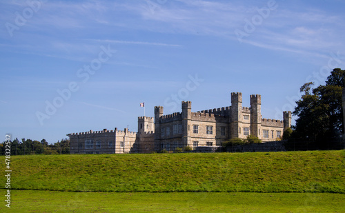 Leeds Castle in the sun, with grass in the foreground and clear sky.